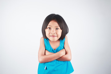 Cheerful little Asian girl excitement and funny face on gray background