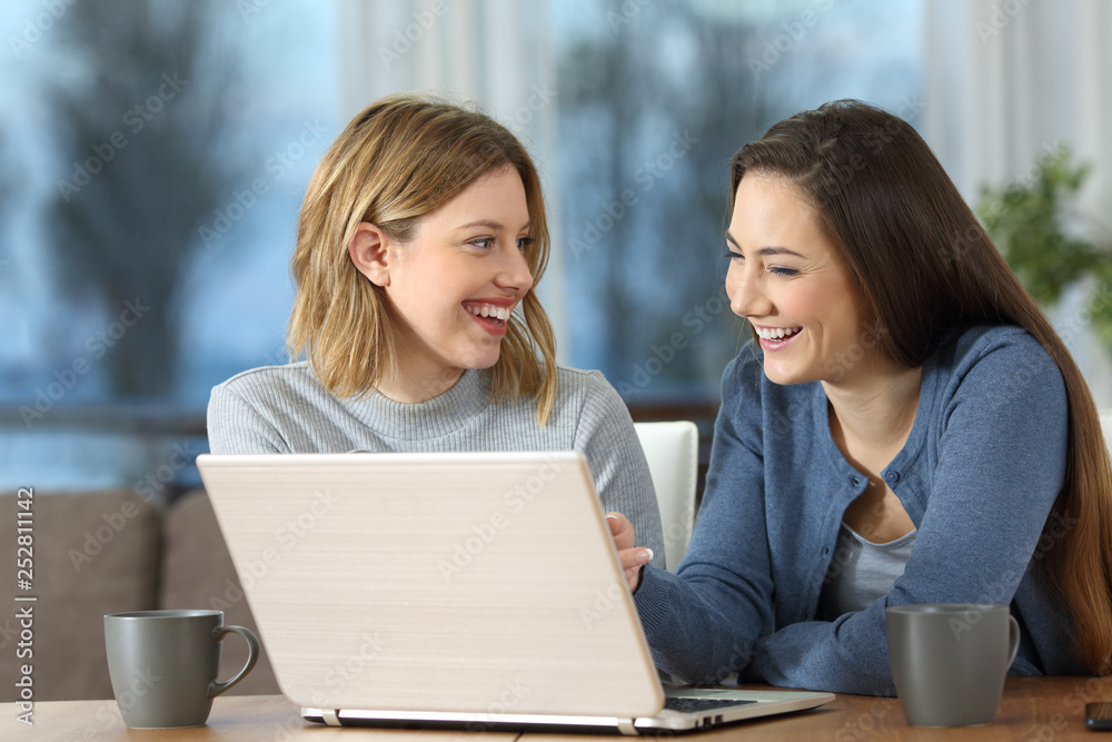 Poster happy friends using laptop and talking at home