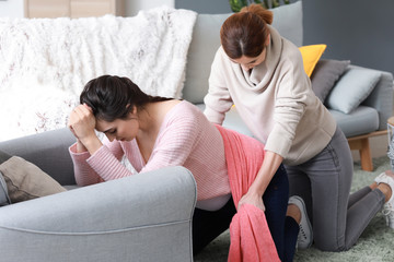 Doula massaging pregnant woman at home