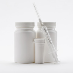 Bottles of pills and syringe