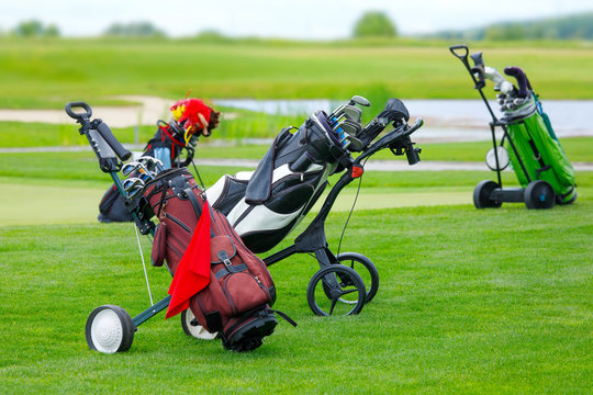 Golf niblick and putter in bags on the golf course with green grass field at summer - luxury recreation hobby for the high society