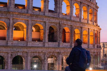 Fototapeta na wymiar Rome/Italy 21 february 2019 :man standing in front of colosseo in Rome he admires the greatness of this landmark