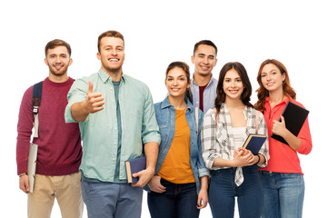 Obraz premium education, high school and people concept - group of smiling students with books showing thumbs up over white background