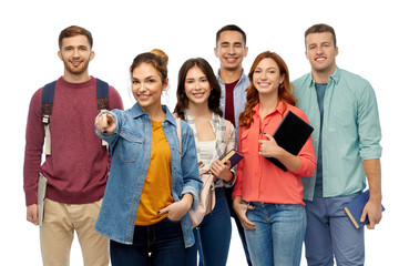 education, high school and people concept - group of smiling students with books and bags pointing...