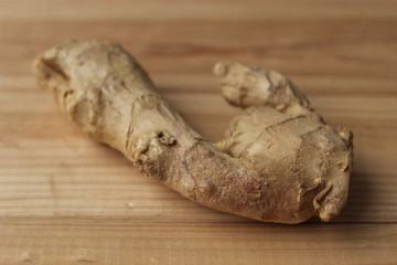 The ginger fruit is fresh, chopped finely, lies on a light wooden base, the concept of health and food