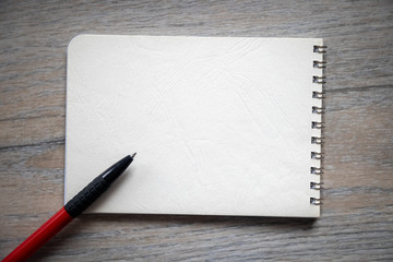 School notebook with pen on wooden table with copy space