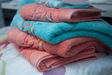 closeup of colorful bath towels pile on bed in decoration store showroom