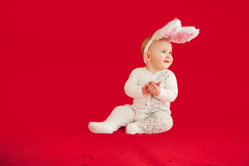 Small beautiful newborn baby crawls on an isolated red background with a gift in kayts komelyum. Concept holidays and costumes
