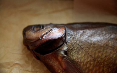 Golden smoked river bream on dark background, top view