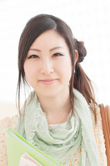 ファイルを持ち微笑む大学生