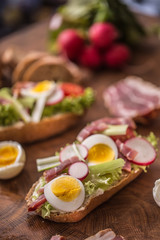 Baguette sandwich fresh vegetable dressing bacon panchetta tomatoes eggs and onion. Healthy nutrition breakfast or appetizer