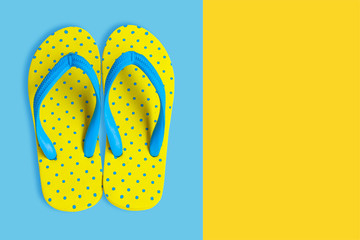 Yellow sandals on yellow and blue color background, flat lay photo