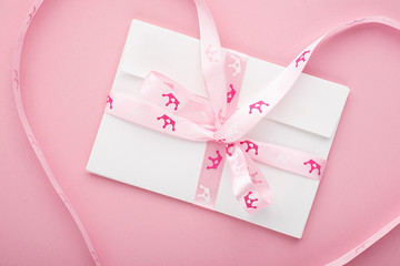 Envelopes for congratulations lettering on a pastel pink background with a princess ribbon crown in pink hues. Horizontal