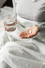 Obraz na płótnie Canvas Ill woman in hospital bed take pills