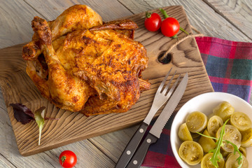 Grilled chicken and marinated tomatoes on wooden background