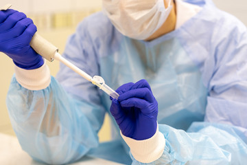 Laboratory assistant with a pipette in his hands for blood testing. 