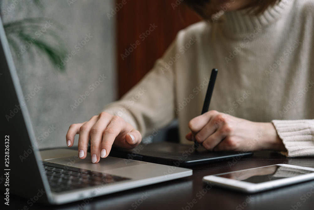 Fototapete graphic designer working from home, using laptop computer and digital drawing tablet to create visua