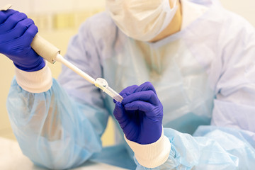 Laboratory assistant with a pipette in his hands for blood testing. 
