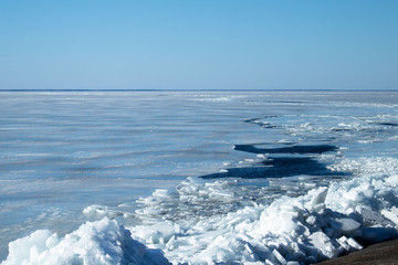 Ice and thawed patches in ice on a reservoir on a winter day