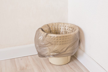 trash can with a plastic bag inside indoor