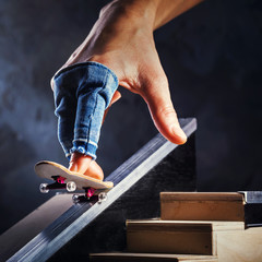 Riding a mini skateboard on a special track. Hand with fingerboard closeup