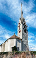 small white European church in a Swiss alpine village in the Grisons