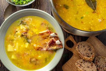 Delicious yellow split peas soup with smoked pork ribs  on a wooden table. Top view