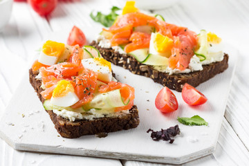 Salmon toast with cream cheese, cucumber and egg. Delicious lunch, healthy food, fish sandwich, diet snack
