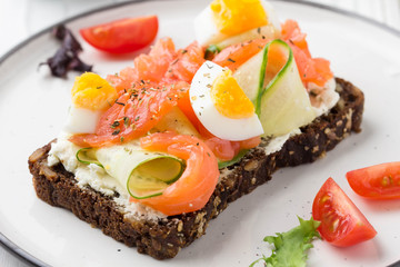 Salmon toast with cream cheese, cucumber and egg. Delicious lunch, healthy food, fish sandwich, diet snack