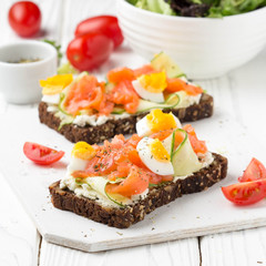Salmon toast with cream cheese, cucumber and egg. Delicious lunch, healthy food, fish sandwich, diet snack