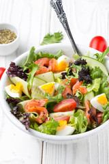 Salad with salmon, egg and vegetables (cherry tomatoes, cucumber, lettuce), delicious light lunch, healthy food