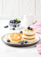 Cheesecakes from cottage cheese, delicious Breakfast, traditional Russian sweet pancakes. With blueberry, mint and sauce