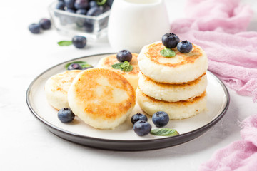 Cheesecakes from cottage cheese, delicious Breakfast, traditional Russian sweet pancakes. With blueberry, mint and sauce