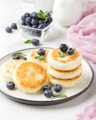 Cheesecakes from cottage cheese, delicious Breakfast, traditional Russian sweet pancakes. With blueberry, mint and sauce