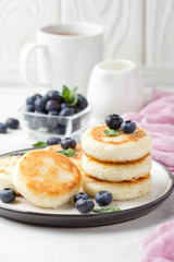 Cheesecakes from cottage cheese, delicious Breakfast, traditional Russian sweet pancakes. With blueberry, mint and sauce