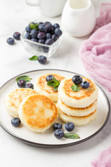 Cheesecakes from cottage cheese, delicious Breakfast, traditional Russian sweet pancakes. With blueberry, mint and sauce