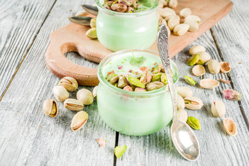 Vegan trend food. Homemade pistachio yogurt with fresh pistachios. On a white wooden table, copy space