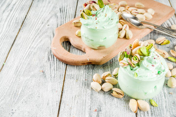 Obraz na płótnie Canvas Vegan trend food. Homemade pistachio yogurt ice cream with fresh pistachios. On a white wooden table,