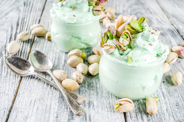 Fototapeta na wymiar Vegan trend food. Homemade pistachio yogurt ice cream with fresh pistachios. On a white wooden table,