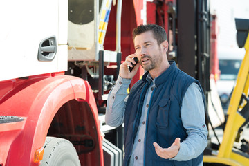 lorry driver making questioning gesture while talking on telephone