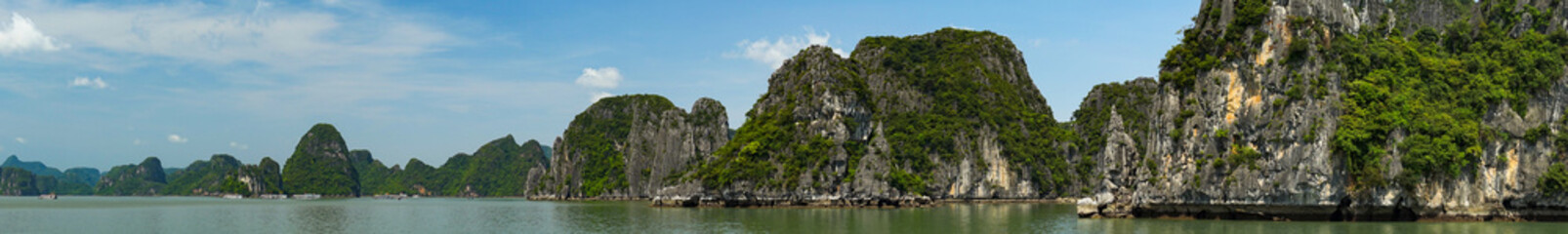 Fototapeta na wymiar Scenic view of the Halong Bay (Descending Dragon Bay) at the Gulf of Tonkin of the South China Sea, Vietnam. Landscape formed by karst towers-isles in various sizes and shapes. Blue sky in background