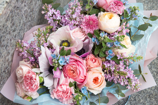 Beautiful rich elegant wedding pink bouquet, flowers arrangement by florist with roses, lilac and blue flowers. Floral background