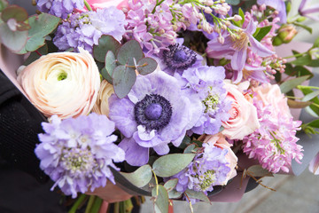 Beautiful elegant pink purple violet bouquet by florist with different flowers and roses close-up, macro. Floral background