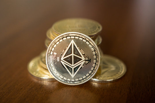 Golden Etherium coin close up. Ether is a cryptocurrency whose blockchain is generated by the Ethereum platform.
