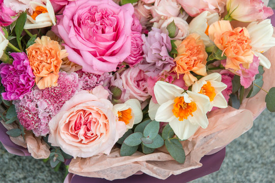 Beautiful elegant spring bouquet by florist with pink roses and narcissus close up, macro. Floral, flowers background