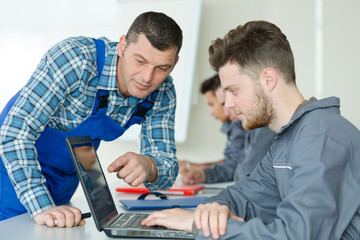 teacher pointing at a program on the trainees laptop