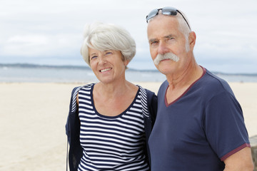 affectionate senior couple on tropical beach holiday