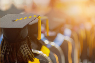 Rear view selective focus of the university graduates crowded in the graduation ceremony. The...