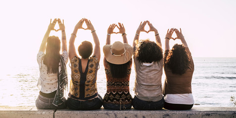 Group of young activist women viewed from rear doing feminism symbol and female power and respect...