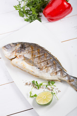 Grilled dorado fish served on a white plate